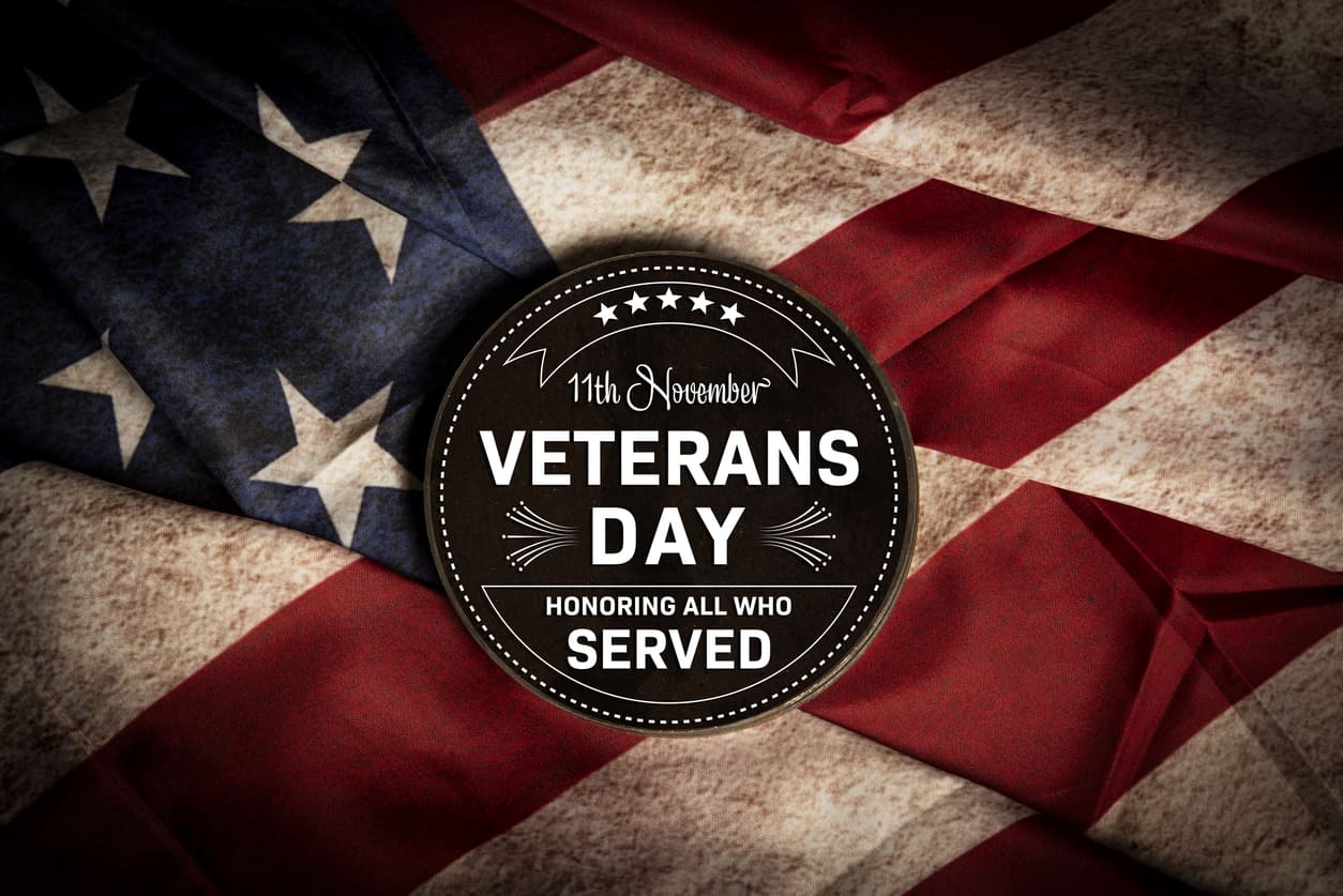11th November Veterans Day metal badge on old USA flag in the background.