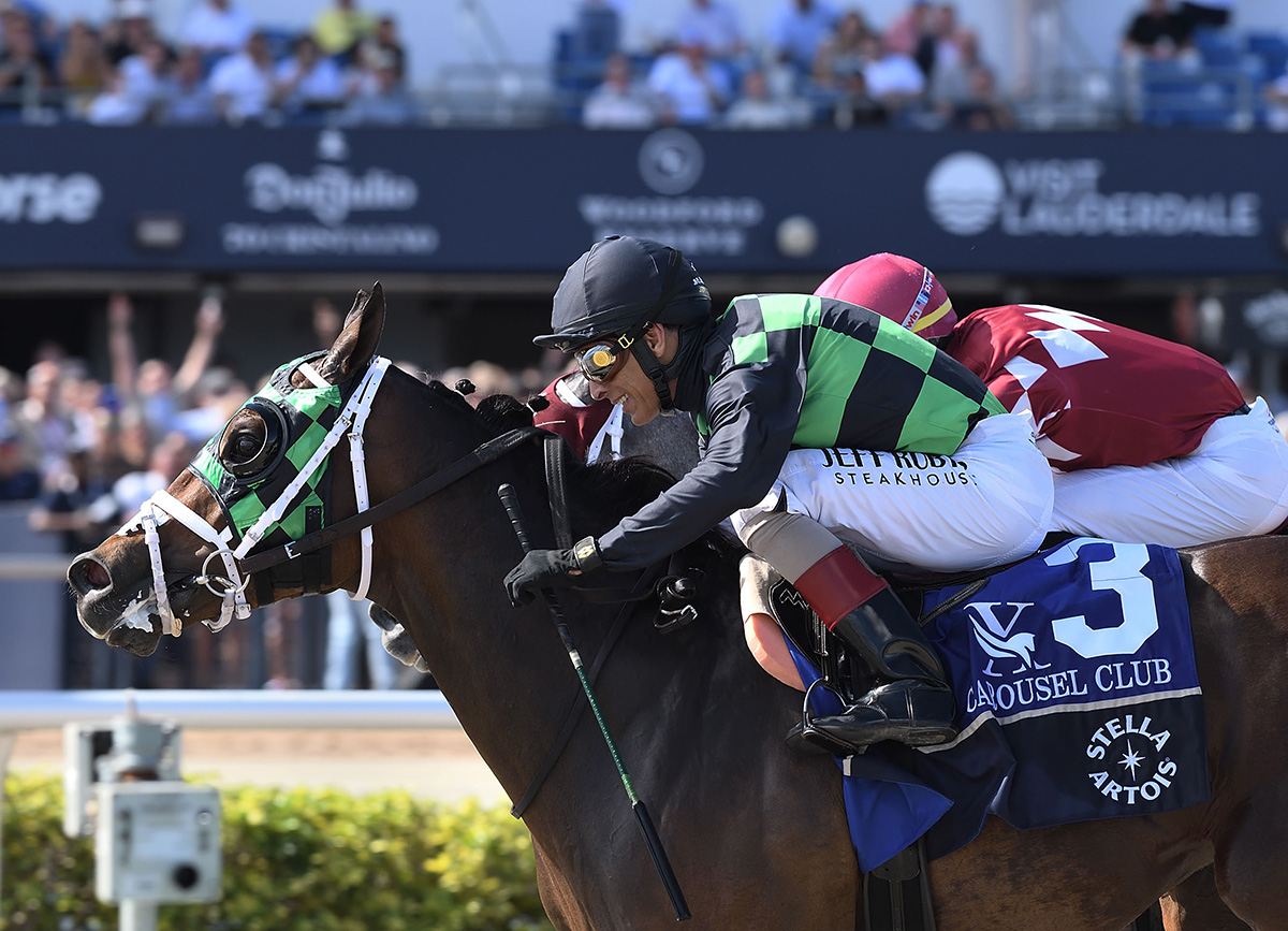 Closely cropped headshot of Florida-bred Thoroughbred Prevent, ridden by Hall of Fame jockey John Velazquez, galloping to the wire in front of the Gulfstream Park grandstands, while competitor Horsepower applies pressure from the outside at Prevent’s neck. Prevent held the lead, winning the 2026 Carousel Club Overnight Handicap by a neck. (Photo: ©Nicole Thomas)