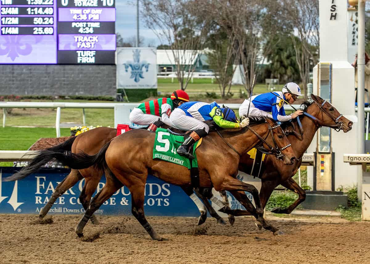 Florida-bred Thoroughbred Taken by the Wind and jockey Brian Hernandez Jr. lead the pack, with competitors Luv Your Neighbor (outside horse) and Atropa (inside horse) bunched around them. The duo held the lead, with Taken by the Wind stretching forward across the wire to win the 2026 Silverbulletday Stakes at Fair Grounds. (Photo: ©Lou Hodges Jr./Hodges Photography)