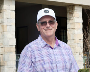Headshot of Tod Wojciechowski, OBS Director of Sales, who smiles for the camera wearing a white “2YO Source” baseball cap. (Photo: ©OBS Photo)