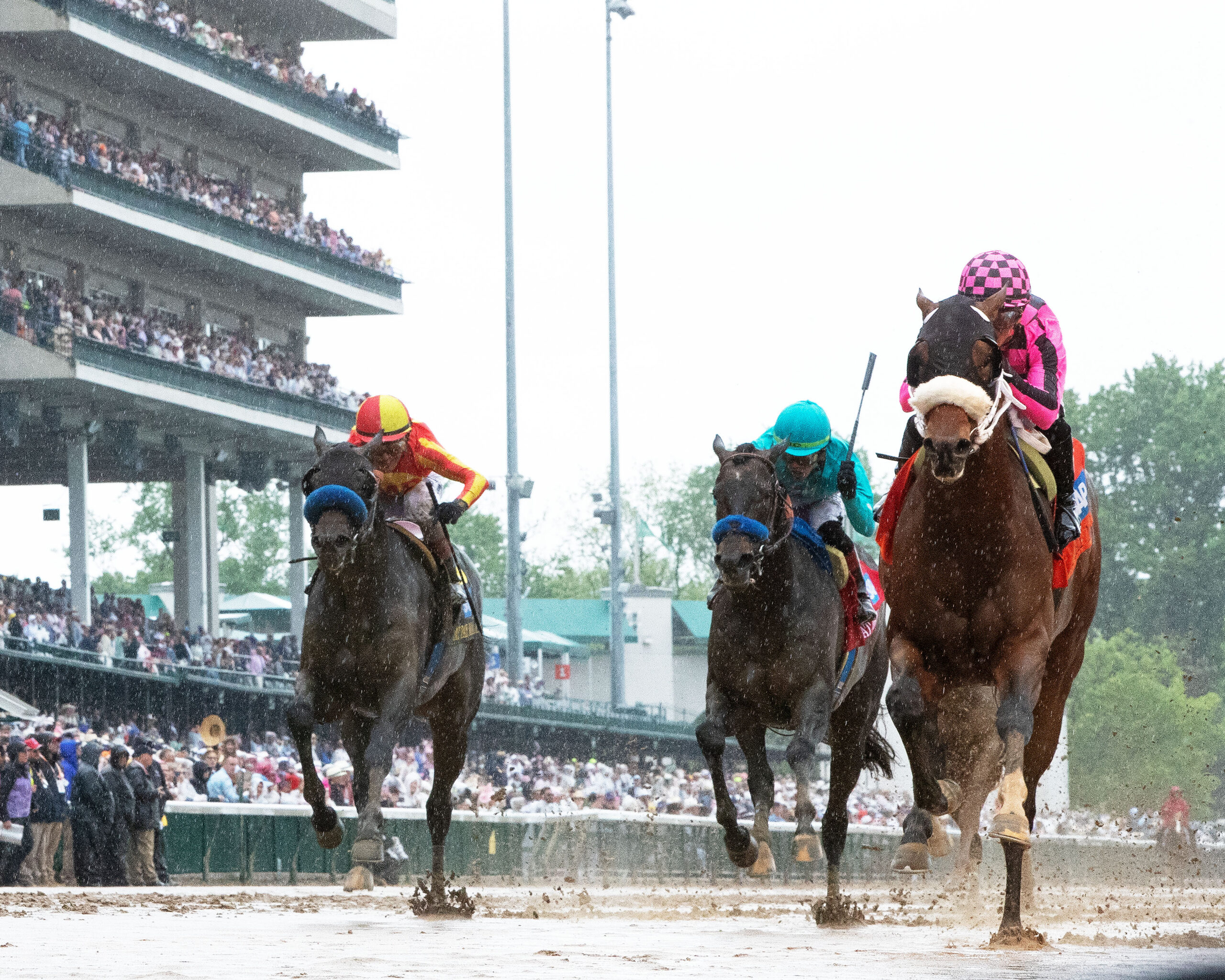 Florida-bred Thoroughbred Macho Music and jockey Javier Castellano rocket to the wire on the inside rail over a sloppy and sealed track. The duo outlasted against competitors Gaming (far outside) and Madaket Road (middle), winning the 2025 Pat Day Mile (Grade 2) at Churchill Downs. (Photo: ©John Gallagher / Coady Media)