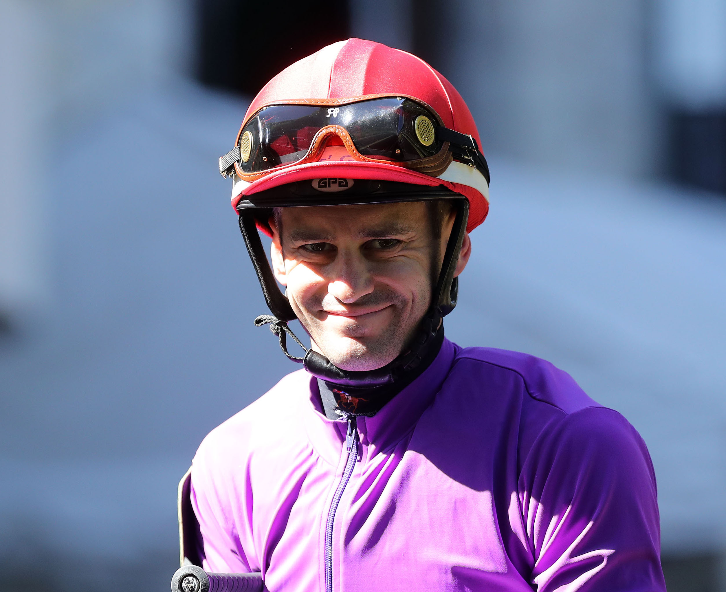 Headshot of jockey Flavien Prat smiling for the camera from horseback (horse out of frame). (Photo: ©Coady Media)