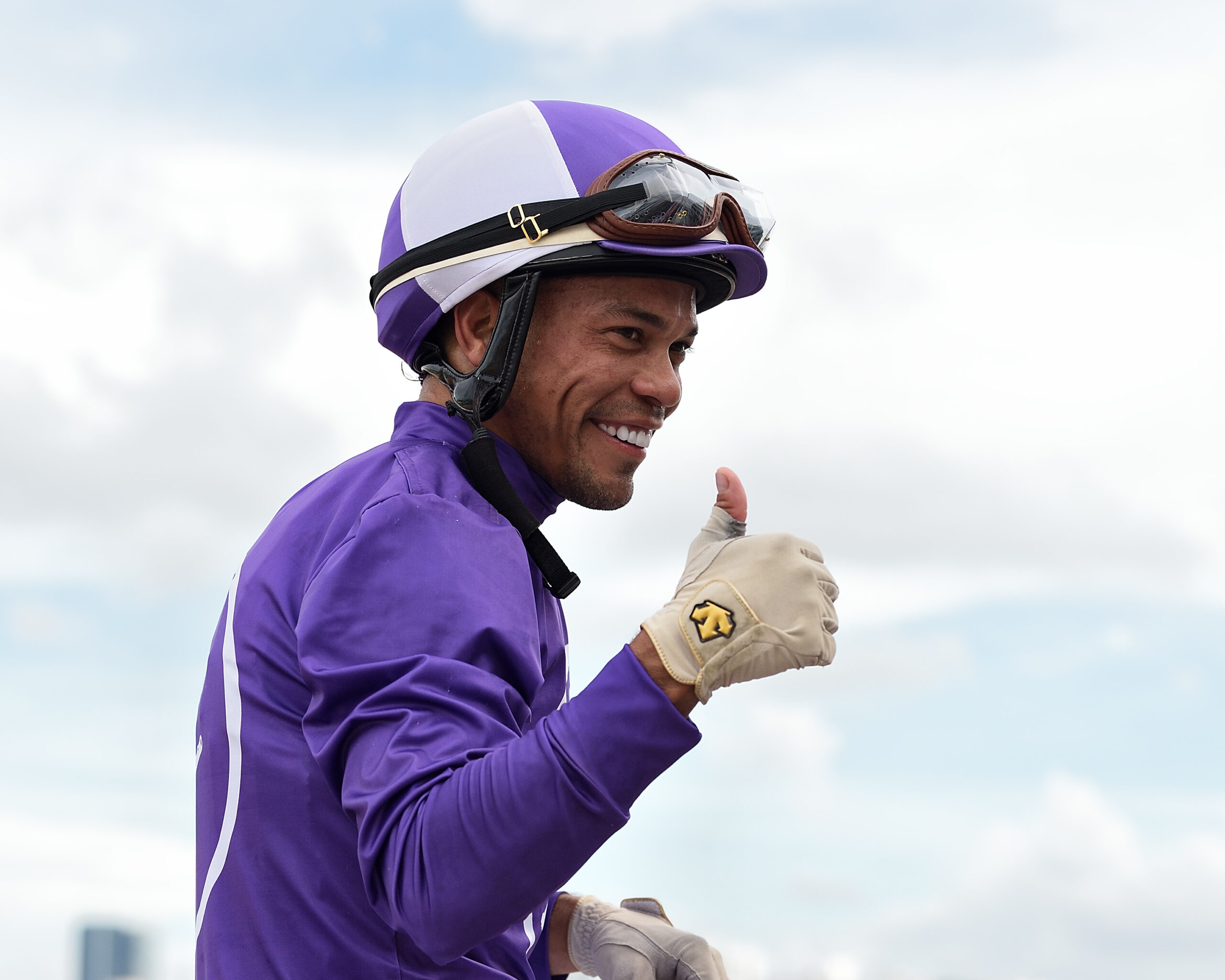 Closely cropped photo of jockey Samy Camacho, smiling and giving a thumbs up to the camera. (Photo: ©Ryan Thompson)