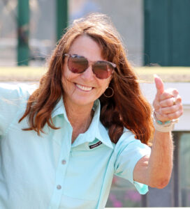 Racehorse trainer Kathleen O’Connell smiles and flashes a thumbs up at the camera while trackside at Monmouth Park after Florida-bred Gerrards Cross won the Monmouth County Stakes. (©Bill Denver/EQUI-PHOTO)