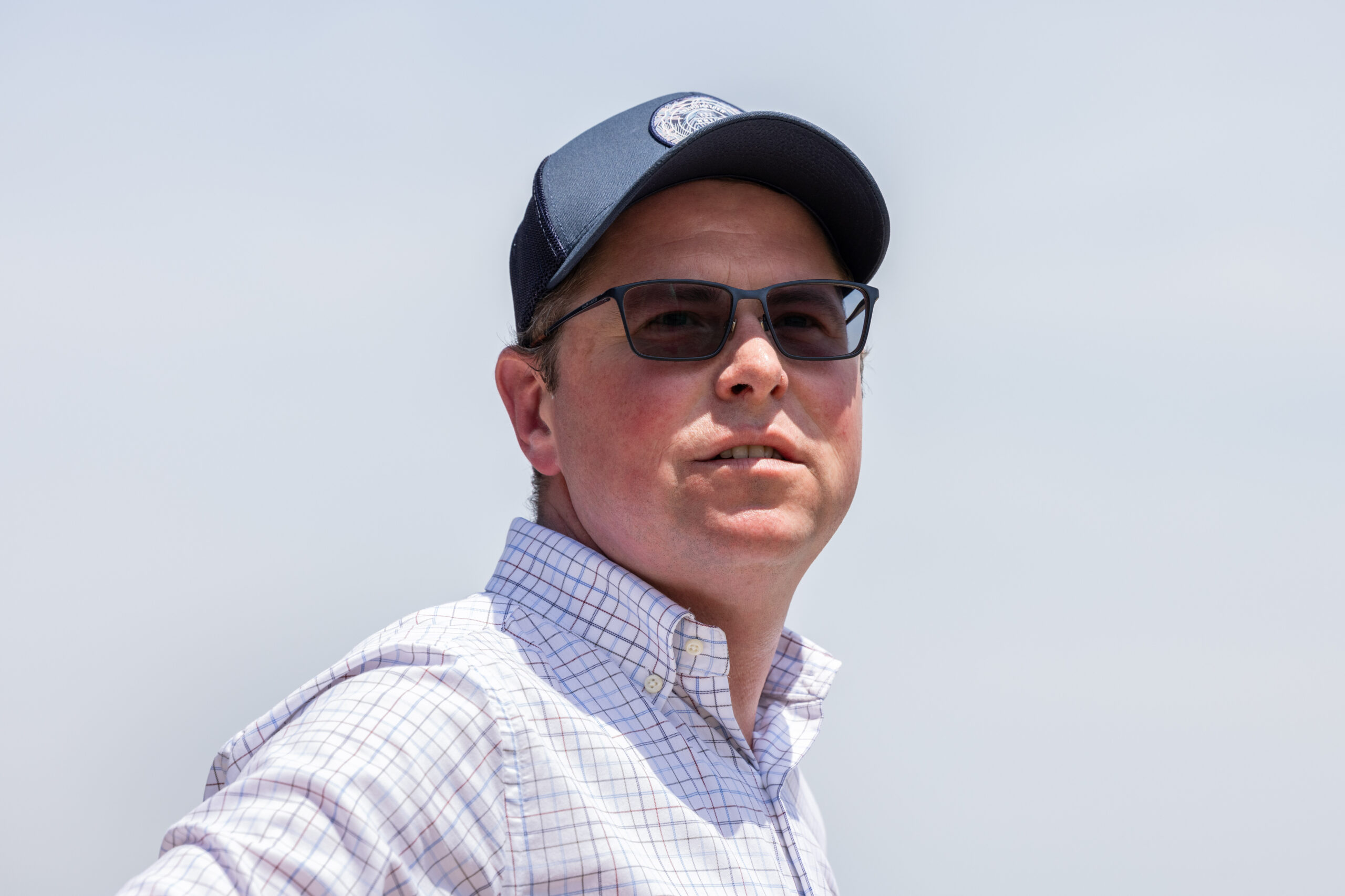 Tilted up headshot of trainer Rob Atlas while trackside. (Photo: ©Walter Wlodarczyk)