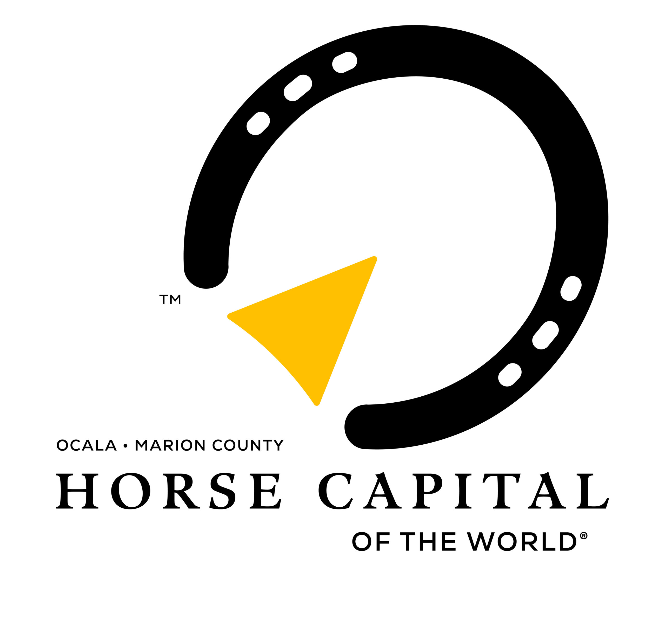 Logo for the Horse Capital of the World®. The logo consists of a black horseshoe pointing to the right. Within it, a yellow arrow doubles as the “frog” of a horse’s hoof, furthering the directional point. Beneath the logo mark, stacked, serif text reads, “Ocala • Marion County, Horse Capital of the World®.”