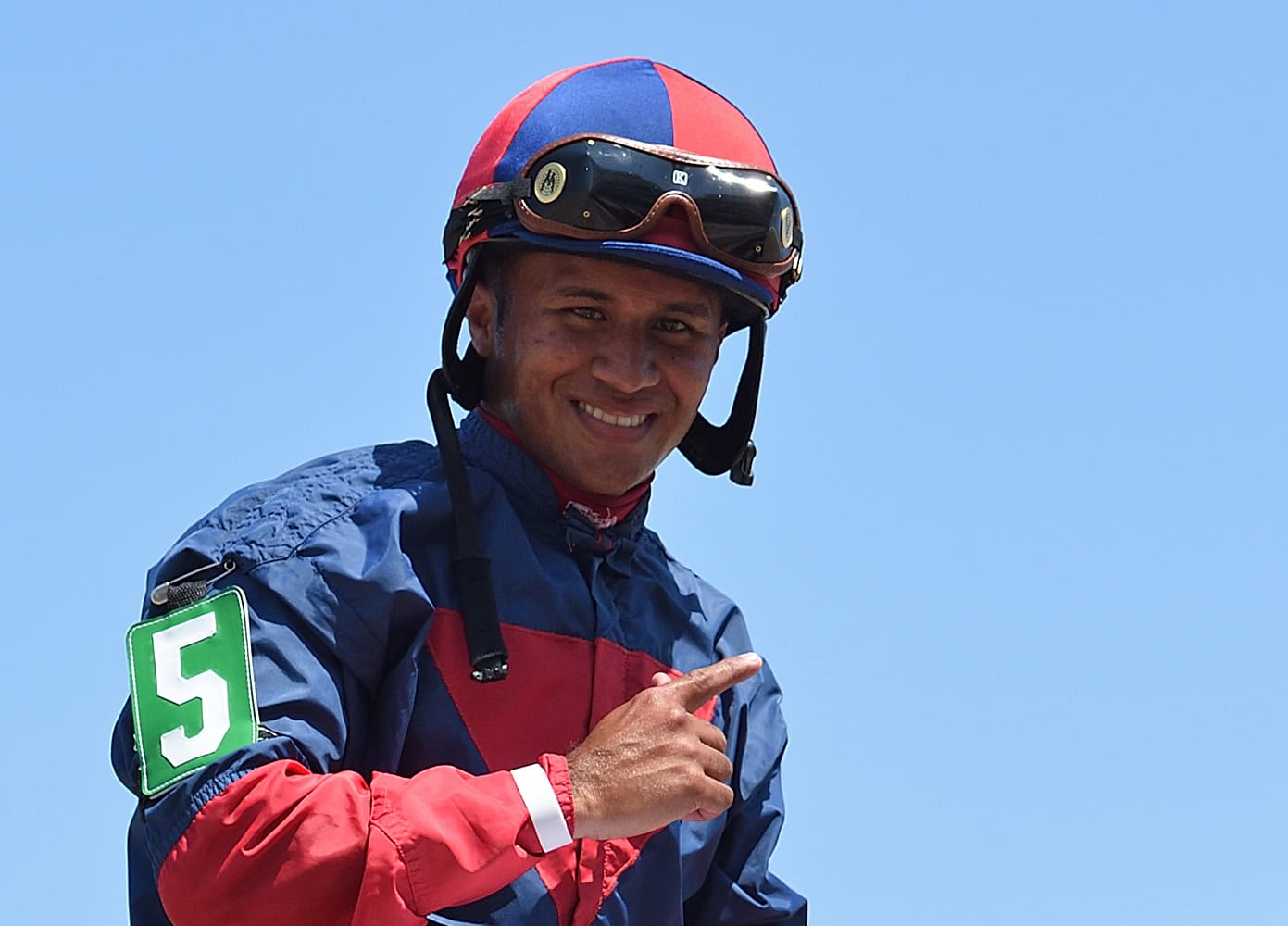 Jockey Miguel Vasquez shows the #1 sign after a win