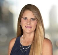 Professional headshot of Beckie Cantrell against a blurred background. 