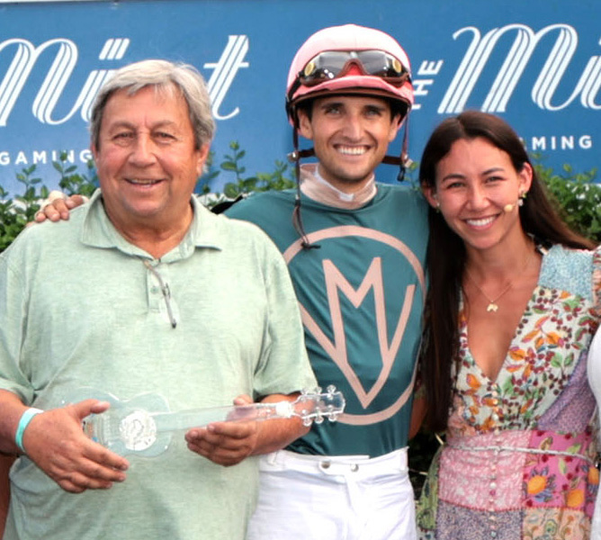 Smiling brightly from the winners circle, Patrick Biancone, Keith Asmussen, and Andie Biancone pose together for a photo as the family celebrates their win with Florida-bred Thoroughbred Laigina (not pictured) of the 2026 Lucky Lantern at Kentucky Downs. (Photo: ©Kurtis Coady/Coady Media)